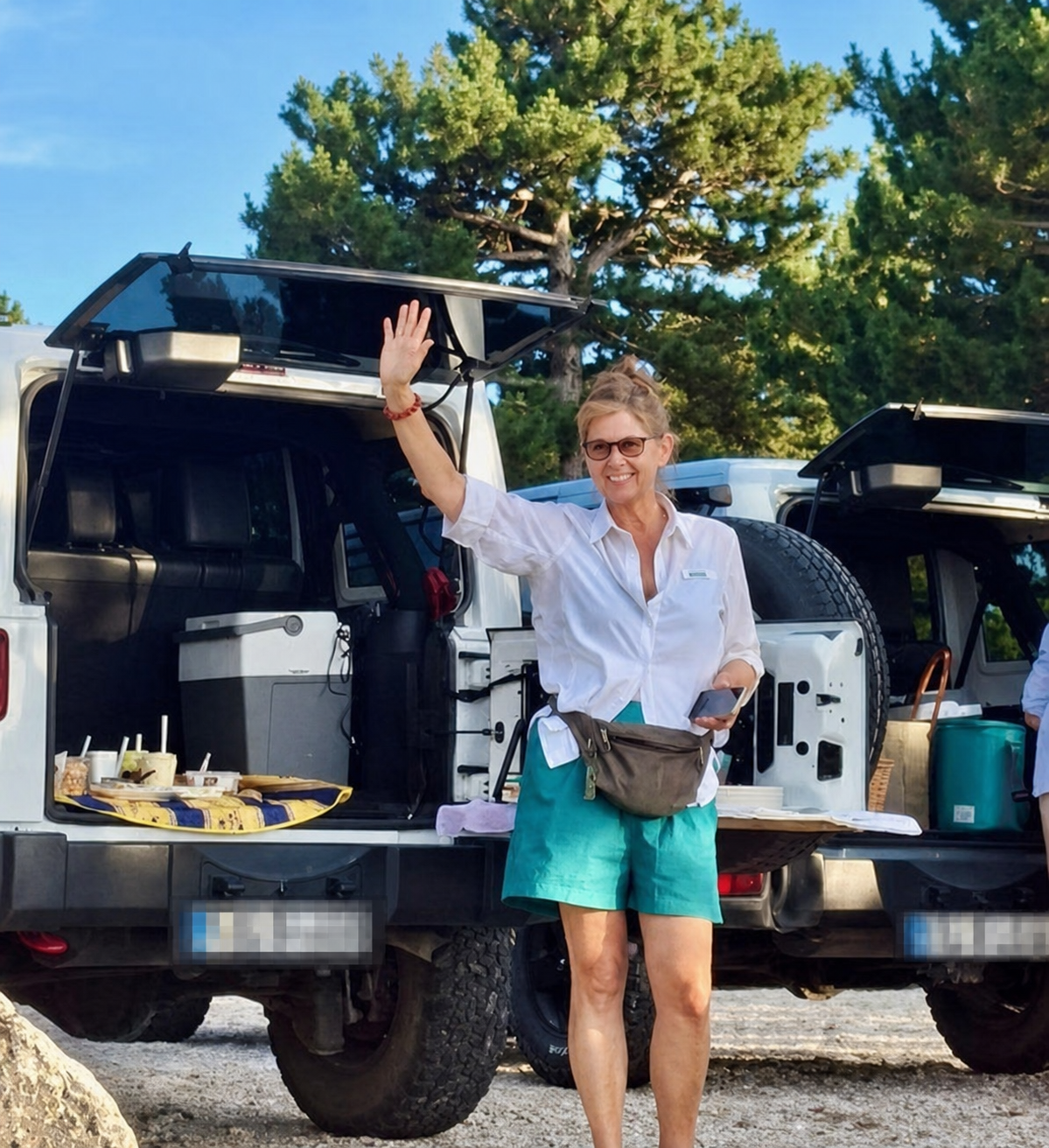 Heike winkt vor zwei Jeeps